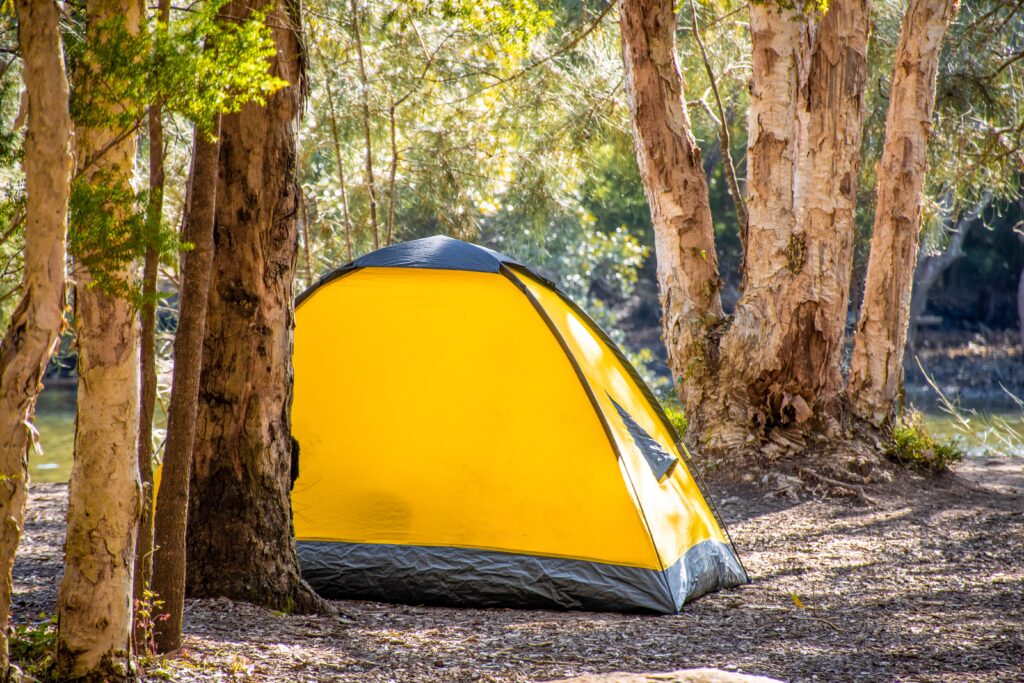 Yellow tent in the forest. Travel tourism camping life concept